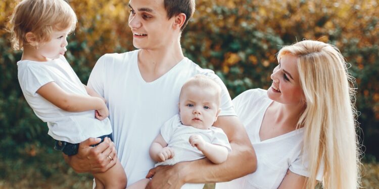 Family with cute little daghter. Father in a white t-shirt. Mother with little son