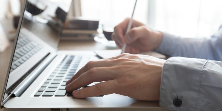 Caucasian man using laptop at table