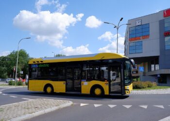 Żółty autobus elektryczny Solaris Urbino z oznaczeniem 100% electric na trasie miejskiej