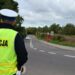 Policjant ruchu drogowego obserwuje drogę w rejonie przejazdu kolejowego