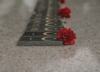 Zapalone znicze i wiązanka kwiatów złożone pod pomnikiem