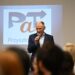 Uczestnik spotkania inaugurującego program PaT przemawia przy ekranie z logo