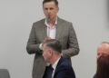 Radny przemawia przy mikrofonie podczas sesji rady powiatu białostockiego