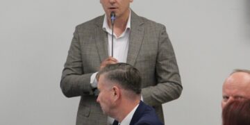 Radny przemawia przy mikrofonie podczas sesji rady powiatu białostockiego