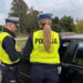 Policjanci z drogówki podczas kontroli samochodu na poboczu drogi