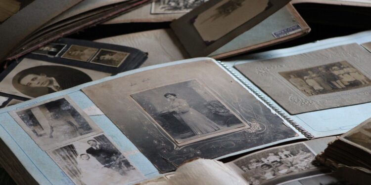 Stare albumy z czarno-białymi fotografiami rodzinnymi rozłożone na stole