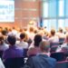 Uczestnicy konferencji siedzący na sali wykładowej podczas prelekcji