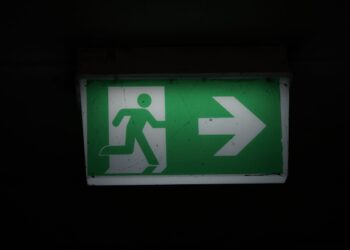 Podświetlony zielony znak wyjścia ewakuacyjnego ze strzałką