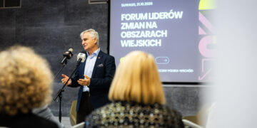 Mężczyzna przemawia przy mikrofonie, w tle baner Forum Liderów Zmian na Obszarach Wiejskich