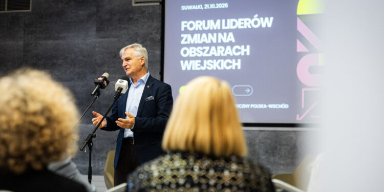 Mężczyzna przemawia przy mikrofonie, w tle baner Forum Liderów Zmian na Obszarach Wiejskich
