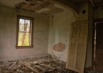 Zniszczona drewniana podłoga w opuszczonym pomieszczeniu starego budynku