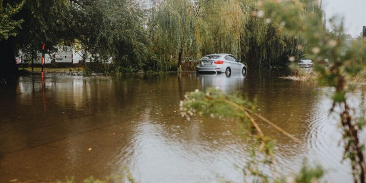Zalana ulica w mieście po ulewie, samochód stoi w wodzie