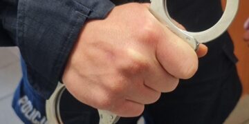 Policjant trzymający kajdanki, zdjęcie ilustracyjne