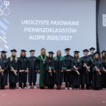 Uczniowie w czarno-zielonych togach podczas ślubowania pierwszoklasistów w auli Politechniki Białostockiej