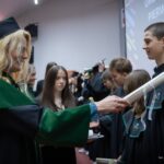 Uczniowie w czarno-zielonych togach podczas ślubowania pierwszoklasistów w auli Politechniki Białostockiej