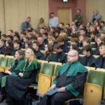 Uczniowie w czarno-zielonych togach podczas ślubowania pierwszoklasistów w auli Politechniki Białostockiej