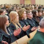 Uczniowie w czarno-zielonych togach podczas ślubowania pierwszoklasistów w auli Politechniki Białostockiej