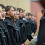 Uczniowie w czarno-zielonych togach podczas ślubowania pierwszoklasistów w auli Politechniki Białostockiej