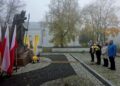 Pomnik Jana Pawła II w Suwałkach z biało-czerwonymi i papieskimi flagami podczas obchodów Dnia Papieskiego