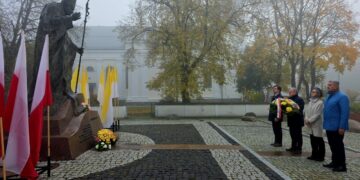 Pomnik Jana Pawła II w Suwałkach z biało-czerwonymi i papieskimi flagami podczas obchodów Dnia Papieskiego
